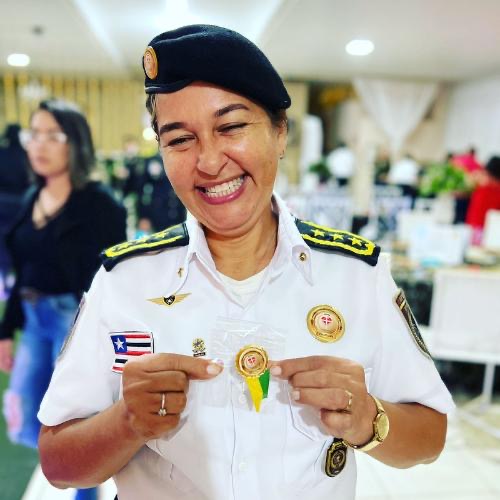 Capelã UNICIM fardada de branco sorrindo ao receber sua indumentária